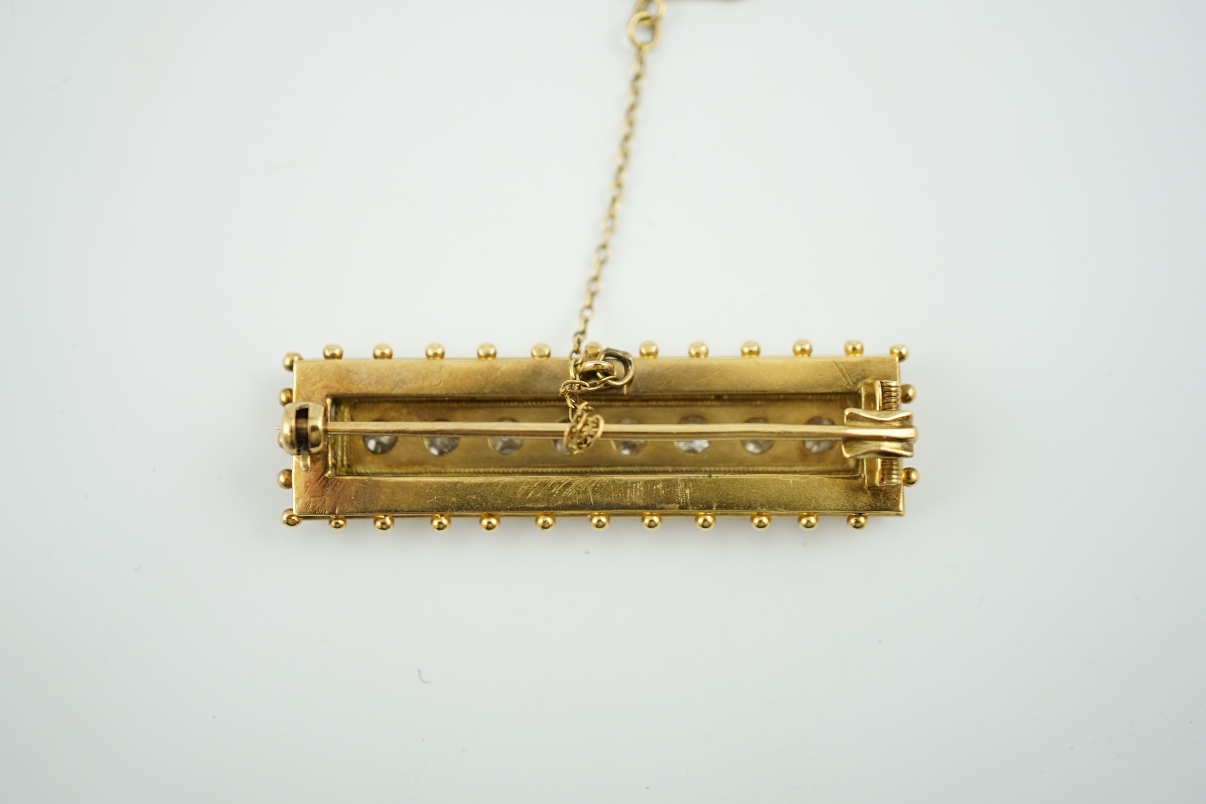 A late Victorian gold and eight stone diamond set brooch, of rectangular form, with beaded border, 46mm, gross weight 9.1 grams. Condition - fair